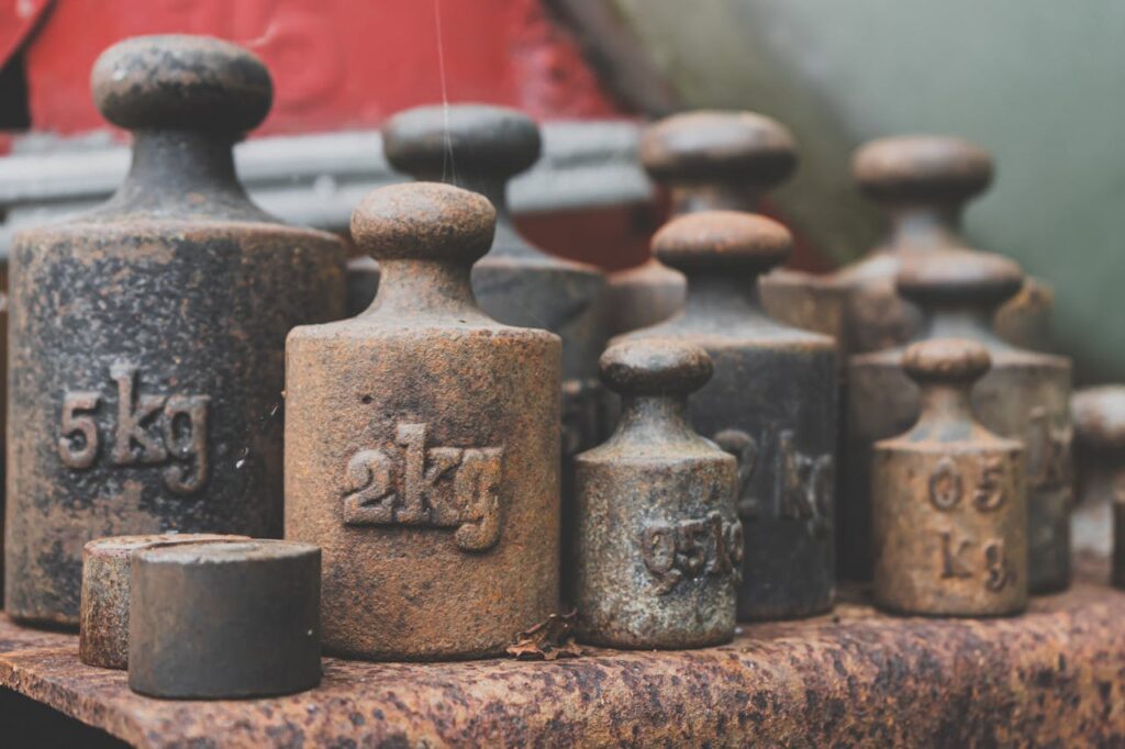cast iron dumbbell Close-up of various rusted iron weights illustrating antique and vintage appeal.