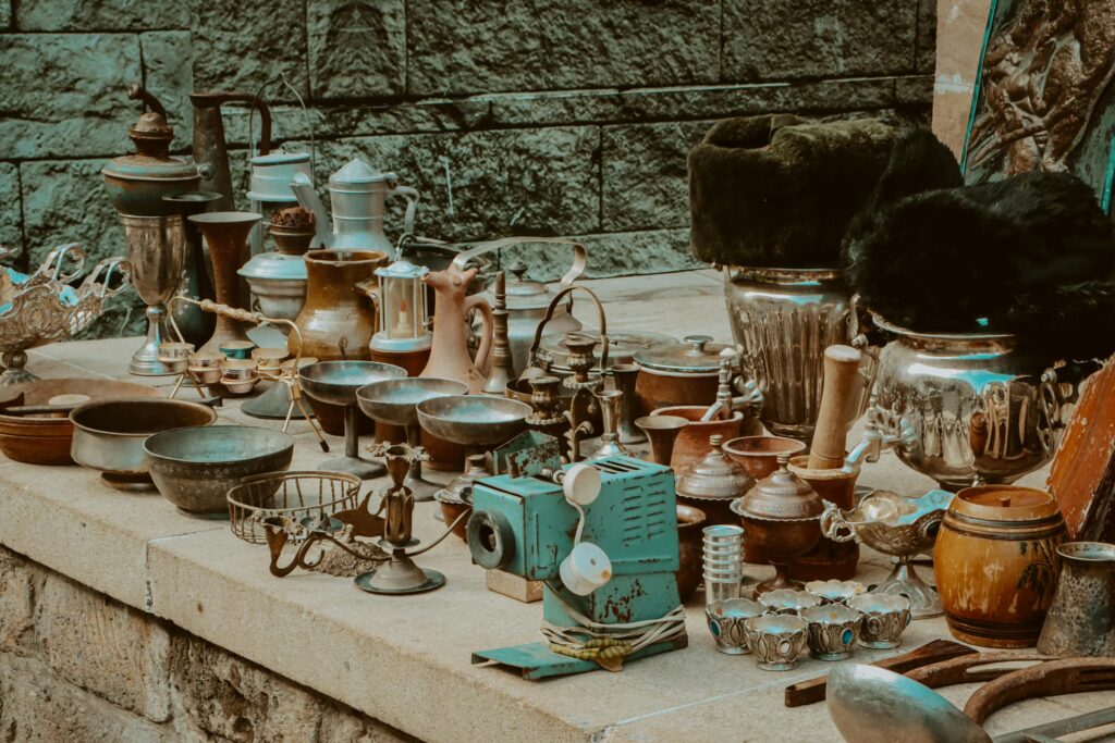 Collection of antique items on a market stall, showcasing vintage kitchenware and decor.