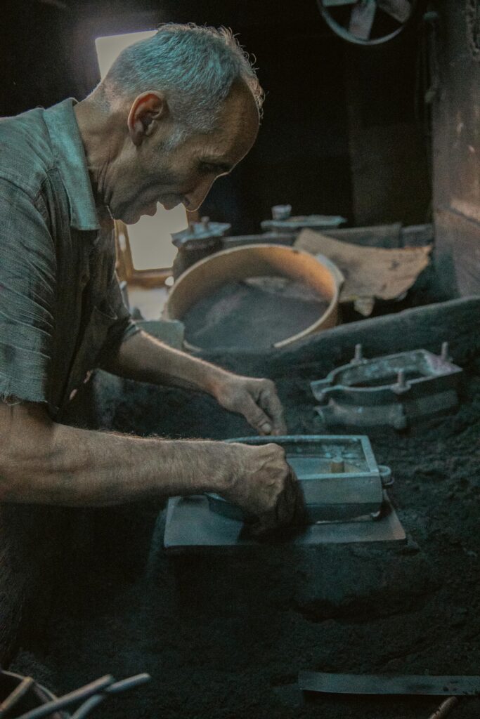 pexels-photo-18720018-18720018 Elderly blacksmith meticulously shaping metal in a traditional workshop setting.